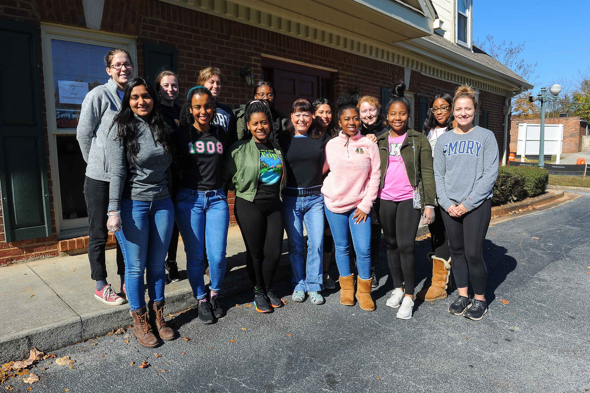 A group of student volunteers pose outside the clinic at Harriet Tubman Women's Clinic